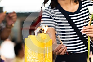 Lighting the candle pray to Buddha, big candle and Flame lit by the big candle`s fire