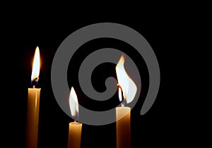 Lighting candles, Burning candle on black background, Candle in hand, Candle in the dark, Design for the background. The light of
