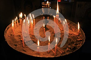 Lighting candles inside a Greek orthodox church.