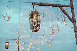 Lighting decor on party outdoors. Cozy lights lanterns, light garland background