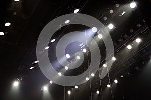 Lighting equipment on the stage of a theatre or concert hall. The rays of light from spotlights. Halogen and led light bulbs