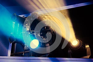 Lighting equipment on the stage of the theatre during the performance. The light rays from the spotlight through the smoke