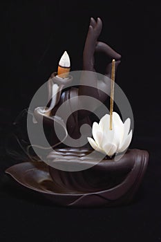 Burning incense on black background in zen figure photo