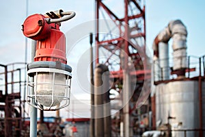 Lighting mast with lantern in explosion-proof and fire-proof design close-up over background of pipelines buildings and equipment