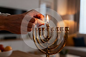 Lighting menorah candles in cozy home setting during hanukkah celebration