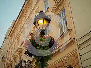Lighting ornate floriated street lamp in an old traditional street at the evening in Budapest