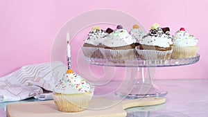 Lighting up birthday candle on cup cake served on the table