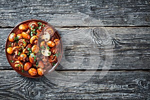 Lightly fried champignons on a clay plate