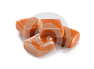 Lightly melted pieces of four toffee caramel candies close-up isolated on white background