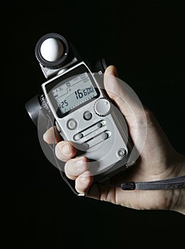 Lightmeter in hands isolated on black photo