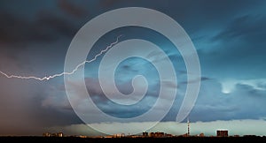 Lightning bolt in storm clouds over city