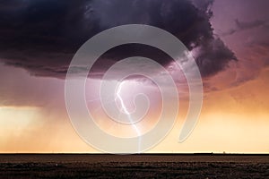 Lightning bolt and storm clouds at sunset