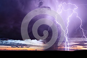 Lightning strike from a powerful storm at sunset. photo