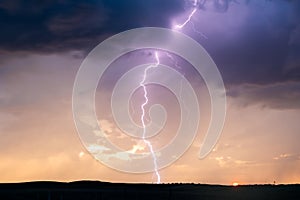 Lightning bolt strike in a storm at sunset