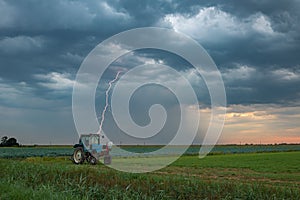 A lightning bolt strikes down behind a tractor