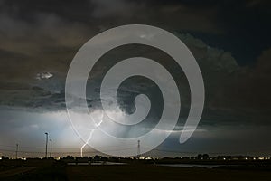 A lightning bolt strikes down to earth from a large storm cloud Cumulonimbus.