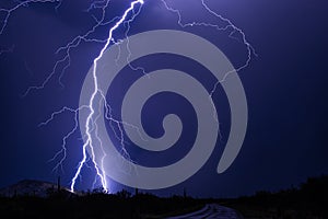 Lightning bolt strikes a hillside during a powerful storm.