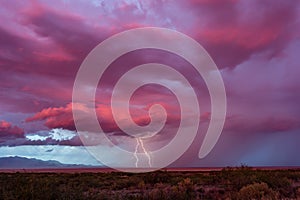 Lightning bolts strike from a distant storm