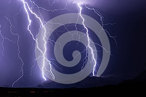 Lightning bolts strike a mountain during a thunderstorm