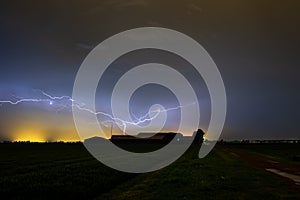 Lightning cleaving the sky above a farm