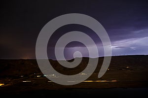 Lightning with dramatic clouds. Night thunder-storm over the mountain and the lake in Baku, Azerbaijan