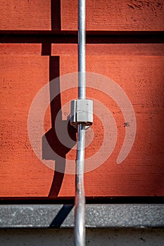 Lightning rod on the wall of a red wooden building. Architecture and structures