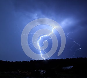 Lightning in sky on the background of trees