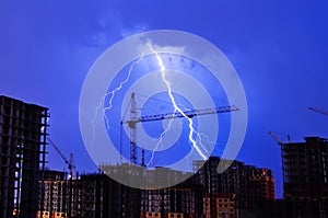 Lightning storm crane weather industrial city building construction night flash