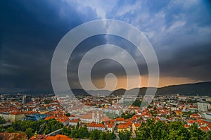 Lightning storm with dramatic clouds over the city of Graz, with Mariahilfer church and historic buildings, in Styria region,