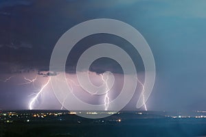 Lightning storm over city. Lightning strike over dark blue sky in night city