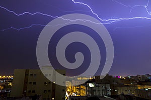 Lightning storm over city in purple light in jeddah al marwah