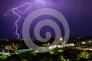 Lightning storm over city in purple light