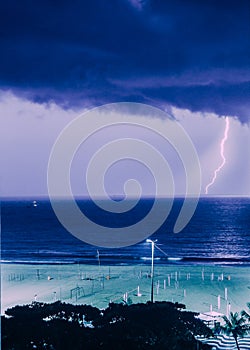 Lightning Strike Over the Ocean Captured at Night Near Beachfront