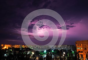 Lightning strikes down over the city at night.