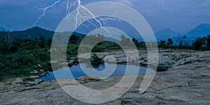 Lightning strikes over a dark forest, top of hill