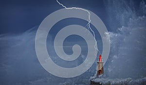 Lightning and wave over old lighthouse.