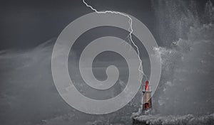 Lightning and wave over old lighthouse.