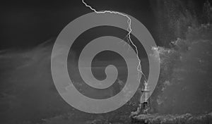 Lightning and wave over old lighthouse.