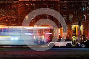 Lightstreaks from a New York City firetruck or ambulance speeding down an empty Harlem street, late at night