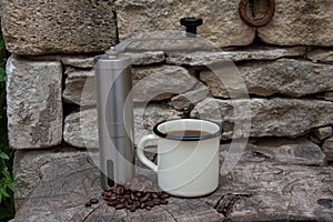 Lightweight coffee grinder for camping and the outdoor life with enamal coffee cup and beans