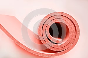 Lightweight foam living coral roll. Yoga mat as swirle on isolated white. Concept