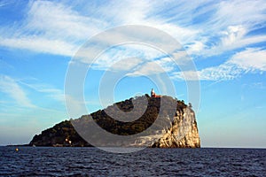 Liguria: view from the boat of the island of Tino with sea rock trees sky and clouds