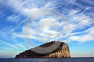 Liguria: view from the boat of the island of Tino with sea rock trees sky and clouds