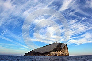 Liguria: view from the boat of the island of Tino with sea rock trees sky and clouds