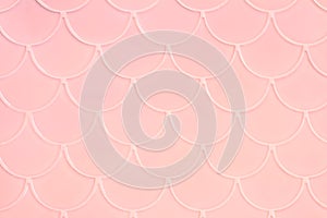 Lihgt pink ceramic tiles in the form of scales. Mosaic Tiles on the wall