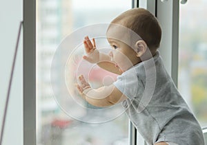 Cute baby boy looking out to the window