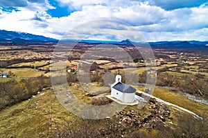Lika region. Church on the hill in Lovinac and Velebit mountain in Lika landscape aerial view