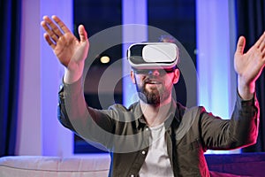 Slow motion of likable cheerful positive man with beard which working on the imaginary touchscreen in augmented reality photo