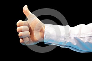 Like. Close-up image of human hand with thumb up on black background