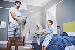 Like father, like son. a handsome young man and his son getting dressed in the morning.